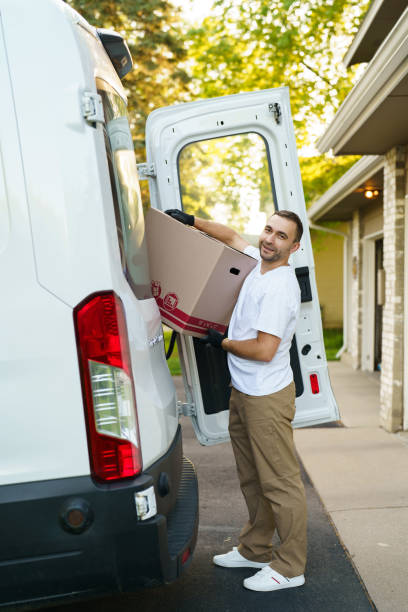 istock Young courier take parcel near delivery car outdoors 2184939111