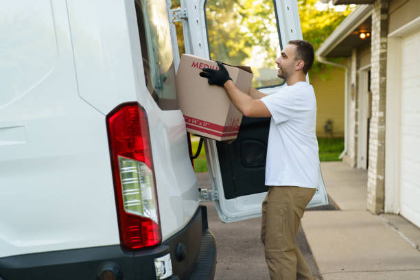 istock Young courier take parcel near delivery car outdoors 2184939236
