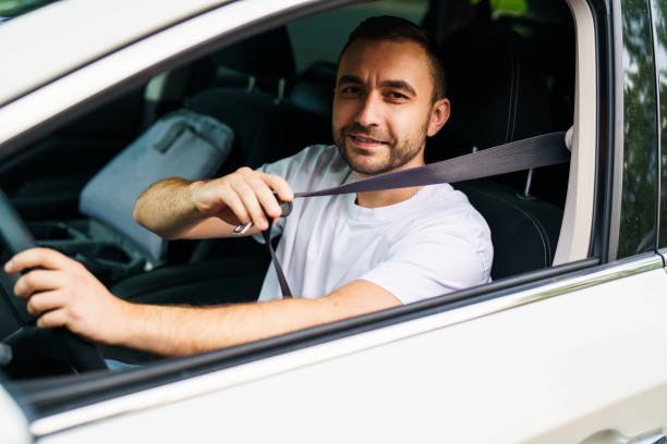 istock Young man pulling seat belt in car, closeup 2184942082