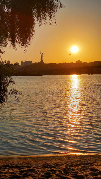 istock Golden Sunset with Statue and Bridge Reflection on River 2184945036