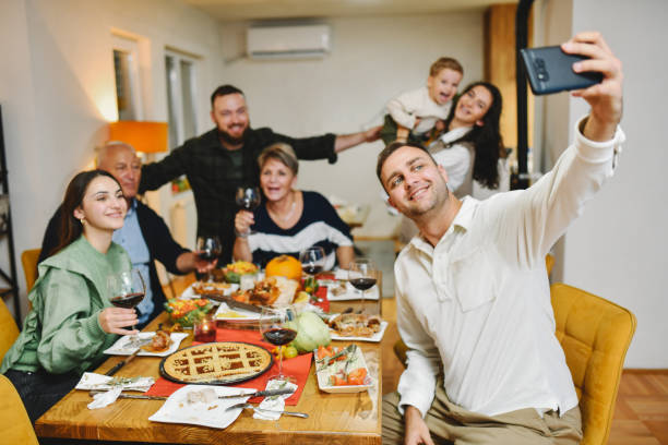 istock Lovely Joyful Family Celebrating Thanksgiving Dinner Capturing Selfie as Memory 2184945385