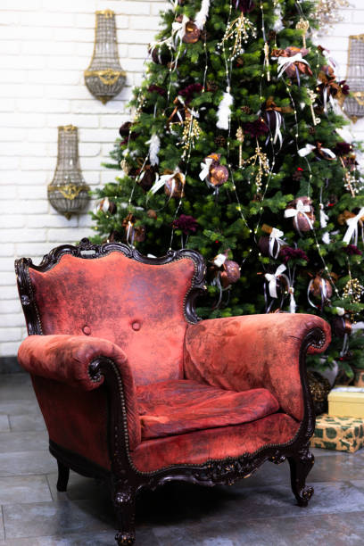 istock Decorated Christmas tree near armchair 2184945420