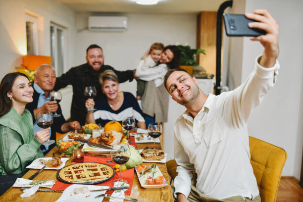 istock Beautiful Smiling Family Taking Selfie on Smartphone While Having Celebration Dinner 2184945960