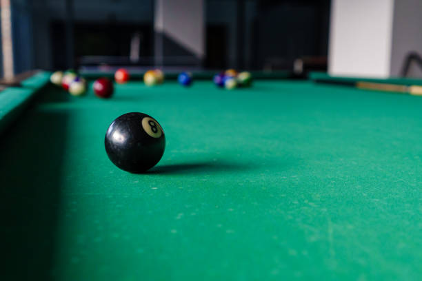 The initial arrangement of billiard balls on the table in the shape of an equilateral triangle in billiards, a close-up of a billiard pyramid, beginning of a pool game, background for a billiard or sports bar, start of a game of eight-ball.