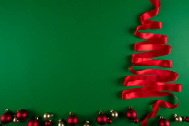 istock Red Ribbon Christmas Tree on Green 2184947851