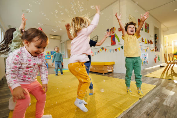 Children having fun playing whit bubbles indoors stock photo