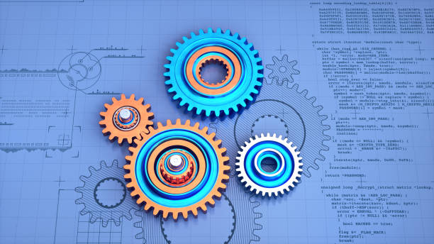 Top view of colorful metallic gears on a blue surface with a blueprint and computer code