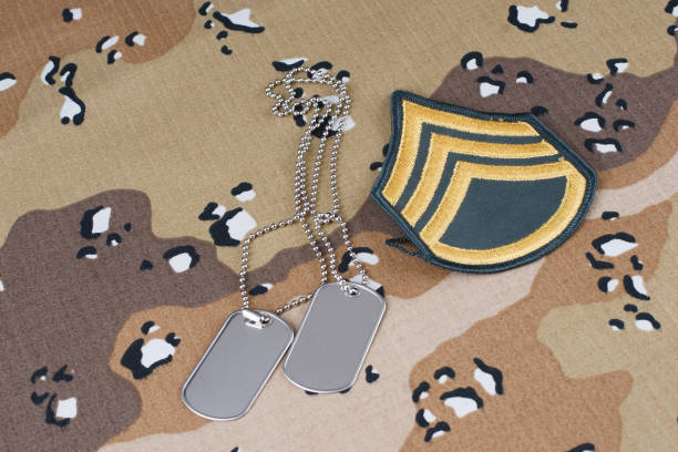 istock US ARMY Sergeant rank patch and dog tags on desert camouflage uniform 2184955915