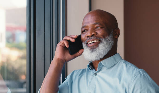 istock Corporate, black man and thinking with phone call in office for communication, contact feedback and schedule. Mature lawyer, mobile and b2b discussion, negotiation deal and legal advice on court case 2184958154