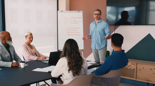 istock Business, man and feedback on whiteboard with clients at office for expense report, presentation and financial growth. People, employees and strategy at boardroom on meeting for review and revenue 2184958298