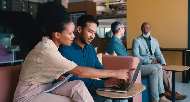 istock Business, people and explain with laptop on couch at office for explaining, meeting and strategy for creative project. Employees, ideas and serious as graphic designer with teamwork and collaboration 2184958441