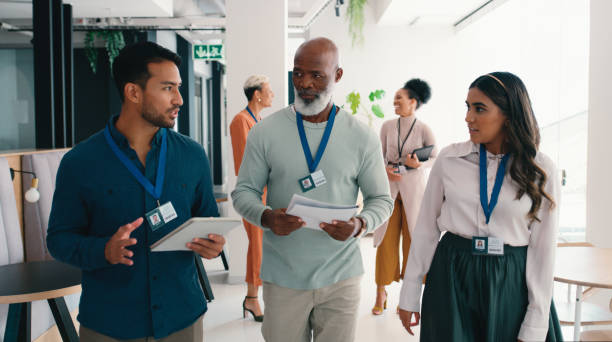 istock Conference, business people and walking at convention center with networking and notes from workshop. Diversity, planning and discussion with professional group at lecture circuit with paperwork 2184958630