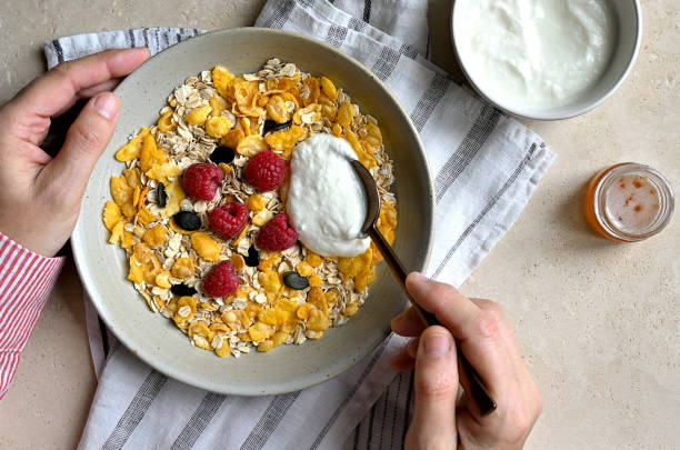 istock Woman who puts cottage cheese on her cereal plate 2184958944