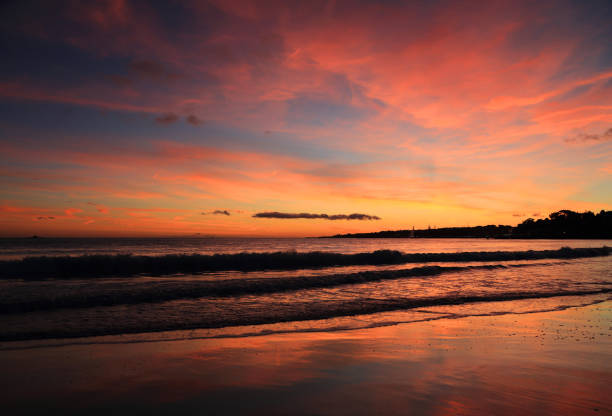 Sunset with a dramatic sky over an empty beach between Oeiras and Cascais, Lisbon, Portugal.