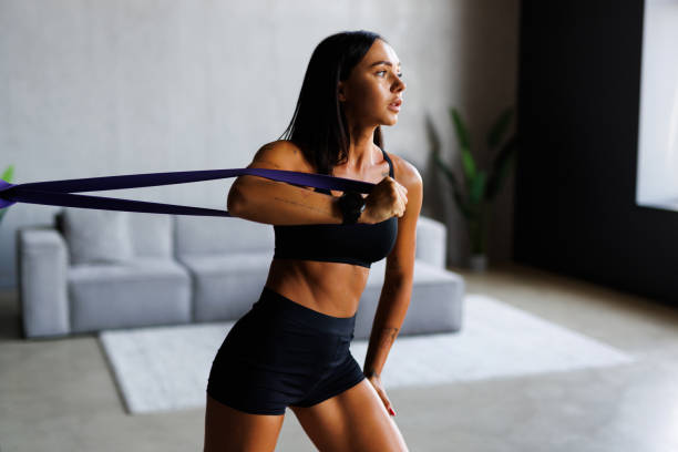 istock Woman during home workout with a rubber resistance bands at home 2184968045