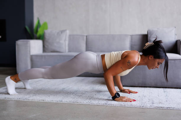 istock Fit woman working on abdominal muscles doing plank exercise at home. 2184968743