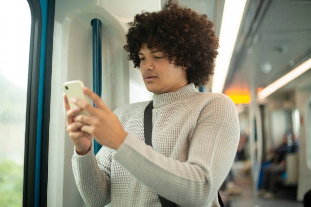 istock Man, phone and texting on train with travel, schedule and reading by window on public transport. Person, student and smartphone with mobile app, click and check time for journey on metro railway 2184970081