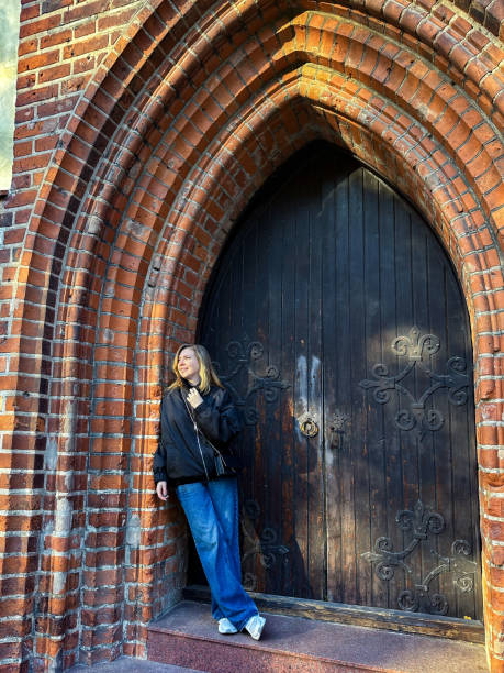 istock Woman Posing by a Gothic Brick Archway at Sunset 2184971278