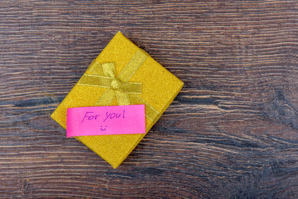 istock Yellow gift box with handwritten note For you. 2184980897