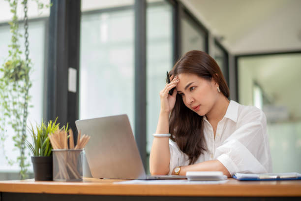 istock business woman sitting at work stressed , out working hard Feeling stressed out and dizzy from your job 2184985713