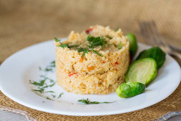 homemade cooked bulgur with Brussel sprouts in a plate, on a wooden table .