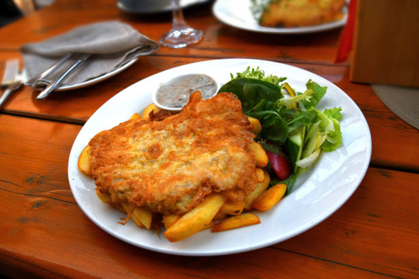 Delicious gourmet pork medallions served with creamy sauce and sides of golden roasted potatoes. Perfect for food presentations, culinary blogs, or high-end restaurant menu inspiration