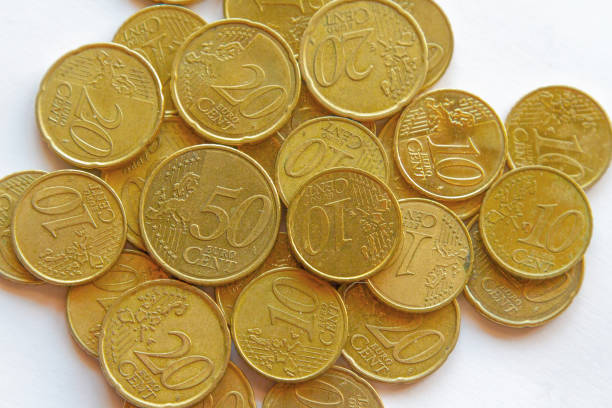 Textured background made of golden euro coins on white background. Suggests abstract economic concepts such as capitalism, inflation, savings. The Euro is the official currency of the European Union.