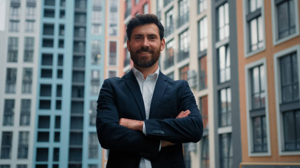 istock Confident boss leader successful businessman male architect standing in confident pose with crossed arms posing alone on city street outdoor modern office buildings professional career growth concept 2184989314