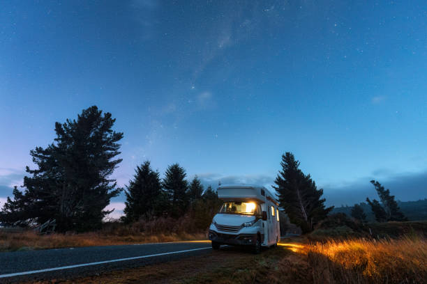 Beautiful milky way with starry in night sky and motorhome parked on roadside at New Zealand