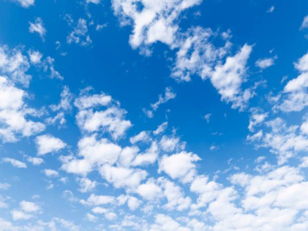 Clear blue sky with fluffy white clouds, creating a serene and calming atmosphere. Ideal for backgrounds or nature-themed projects.