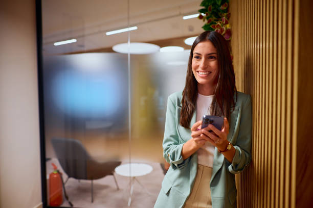 istock Confident Businesswoman Relaxing with Smartphone in Modern Office 2184997567