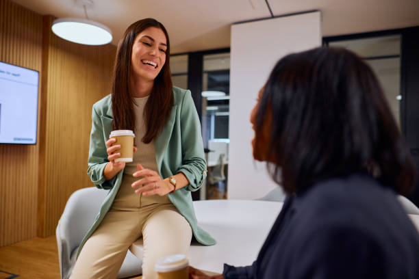 istock Businesswomen Engaged in Friendly Conversation Over Coffee in Office 2184997654