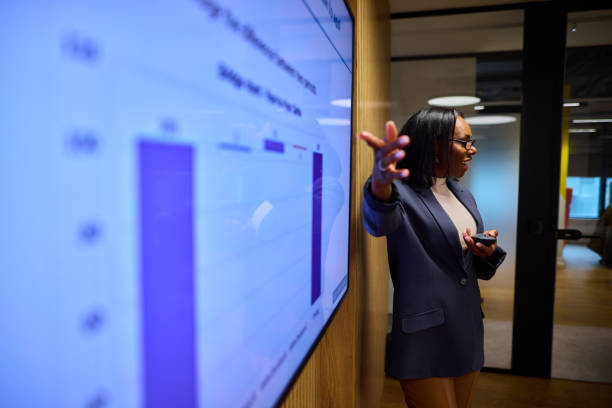 istock Confident Black Businesswoman Presenting Data on a TV Display 2184997741