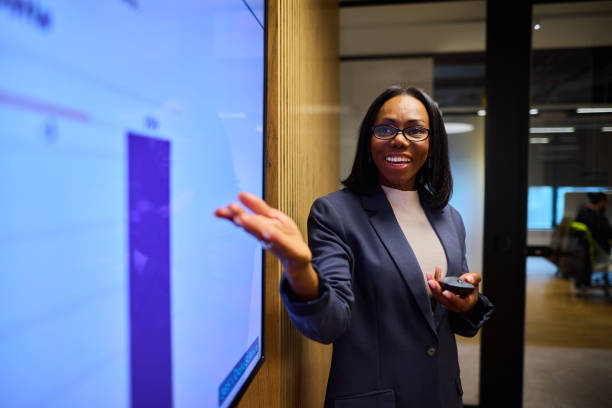 istock Confident Black Businesswoman Presenting Data on a TV Display 2184997745