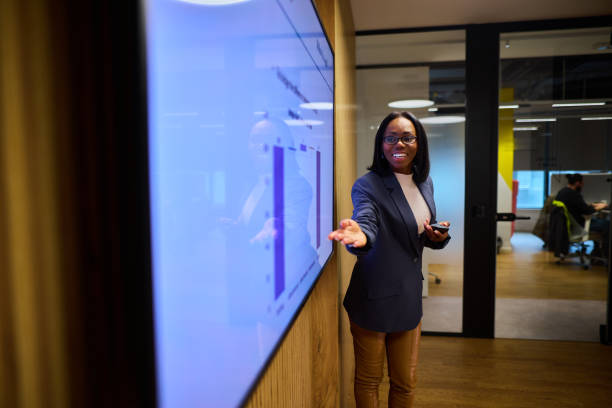 istock Confident Black Businesswoman Presenting Data on a TV Display 2184997747