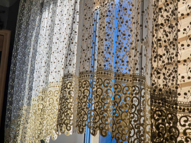 istock Beautiful lacy curtains gently fluttering in the sunlight, creating a warm and inviting atmosphere in a bright room. 2184999189