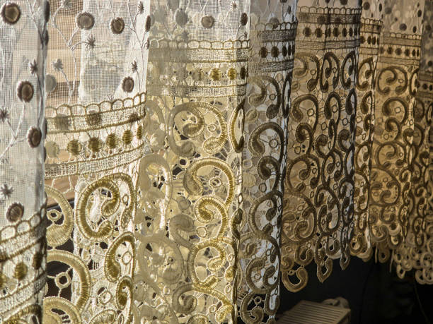 istock Decorative lace curtains in sunlight casting intricate shadows 2184999514