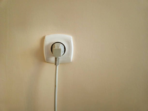 istock A close-up of an electrical outlet with a plug inserted, set against a plain, light-colored wall. Ideal for home, energy, or technology themes. 2184999752