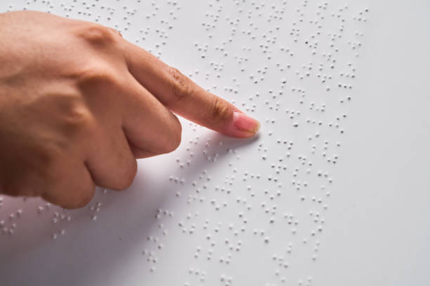 istock A woman hand reading braille with blue background. Annual celebration 2185000966