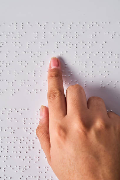 istock A woman hand reading braille with blue background. Annual celebration 2185000970