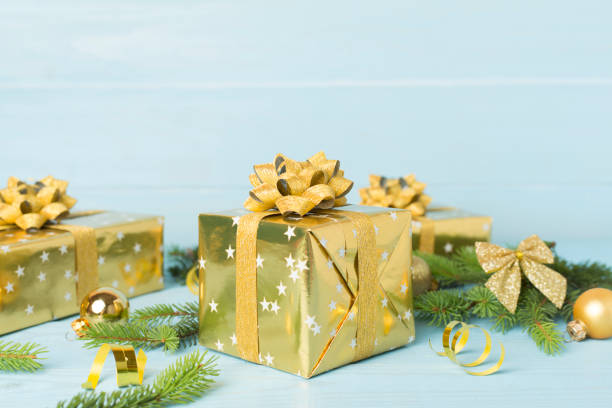 istock Golden gift box with christmas decor on wooden table 2185004280