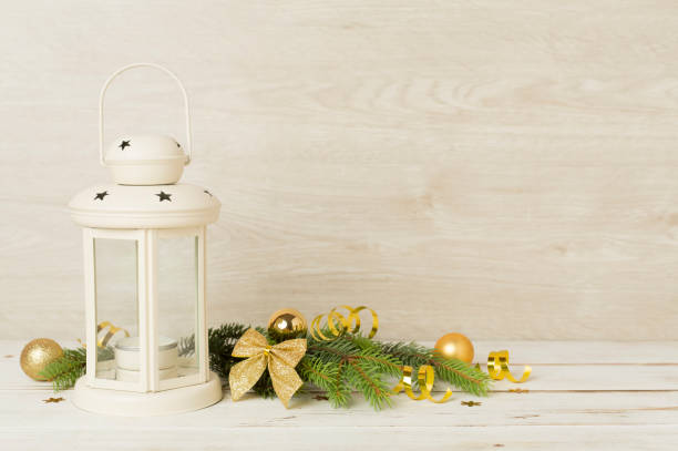 Beige christmas lantern with decorations on color background