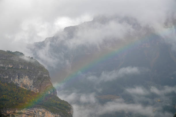 Torla Ordesa Huesca Aragon Spain  Mondarruego peaks  with a rainbow. Border of  The Ordesa Valley, located in the heart of the Pyrenees in Spain, is one of the most emblematic and visited areas of the  National Park  .