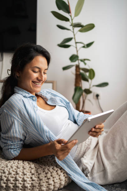 istock Woman enjoying afternoon at home while using digital tablet 2185004692