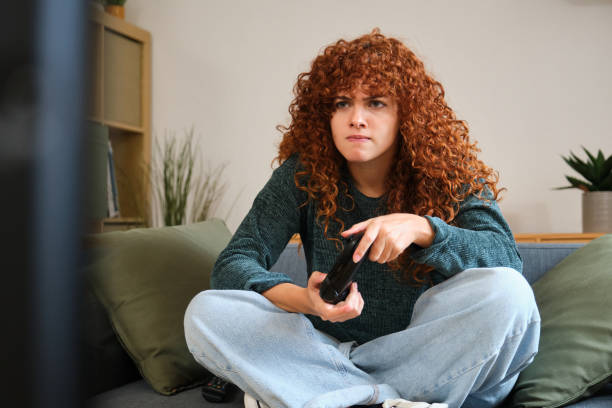 istock Focused woman playing videogames on sofa at home winning a difficult level 2185004829