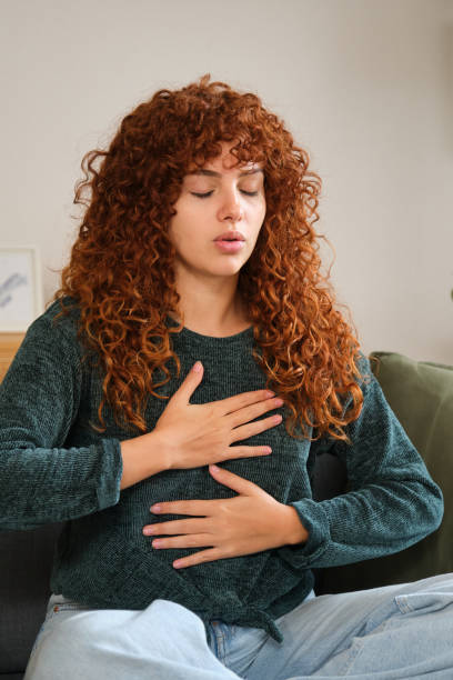 istock Young woman practicing deep breathing exercise at home 2185005844