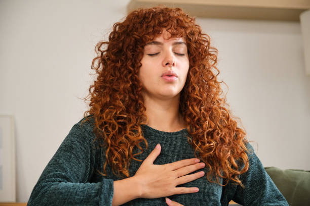 istock Redhead woman practicing deep breathing exercise at home 2185005897