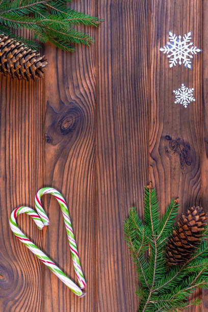 istock Christmas candy canes and pine cones on wood background. Copy space. 2185005932