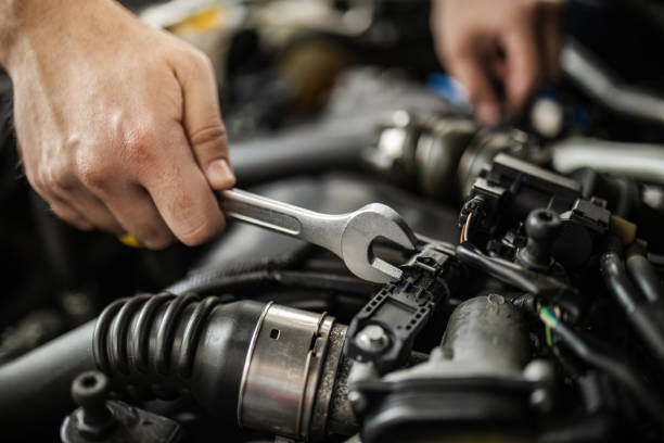 istock A mechanic repairs an engine using a wrench in an auto shop during the day while focusing on the intricate details of the components 2185009239