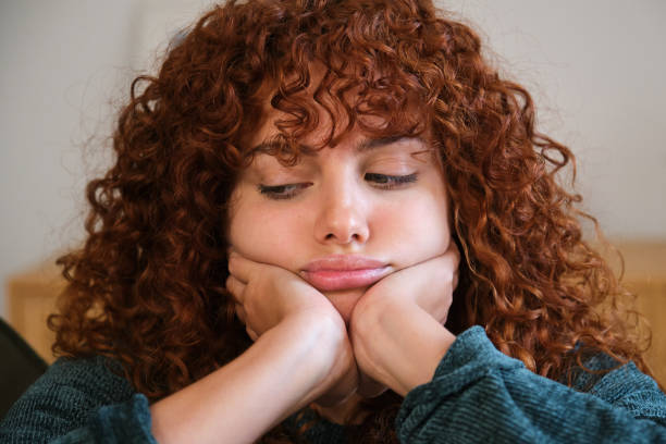 istock Bored young woman resting her face on her hands 2185009534